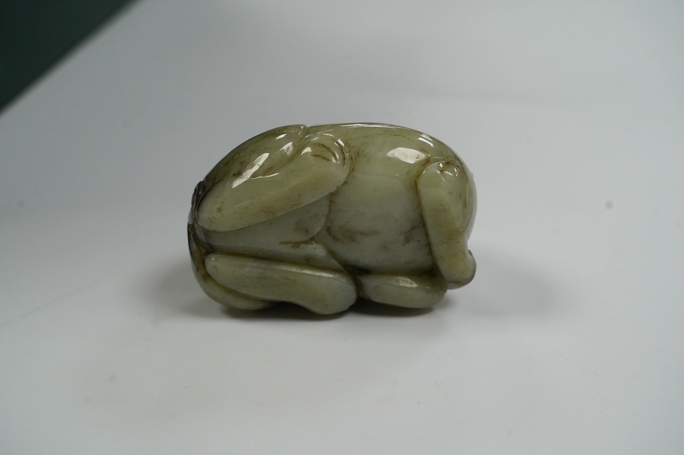 A Chinese jade figure of a lion-dog, 7.5cm wide, 4.3cm high. Condition - good